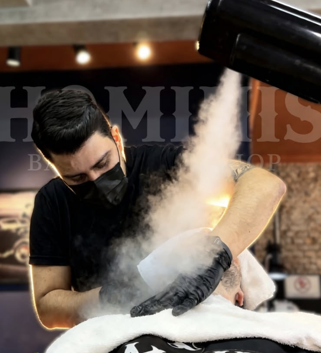 Barbeiro da Hominis aplicando toalha quente no cliente